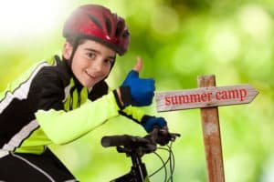 boy on bike excited about summer camp